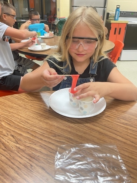 A student looks at her goop she made in Summer School.