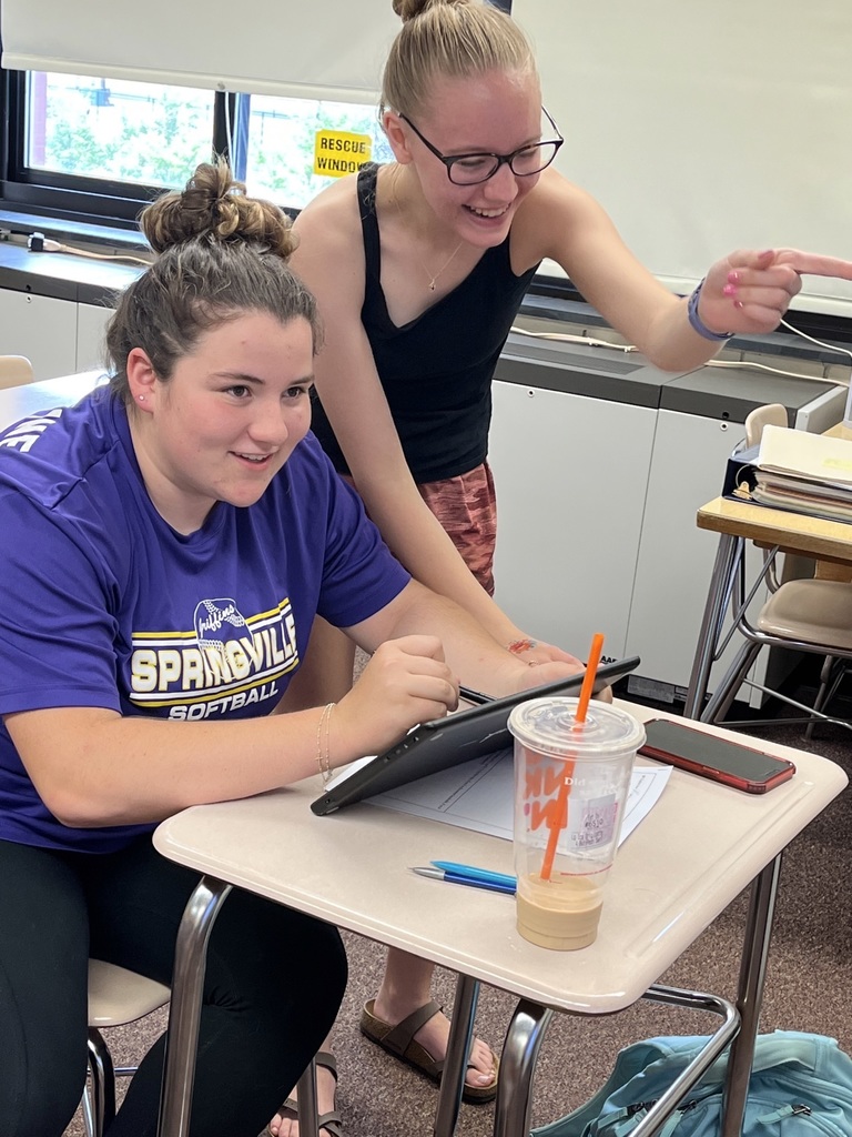 Students engage and point after looking at a tablet.