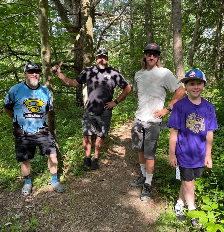 Students and volunteers stand and smile.