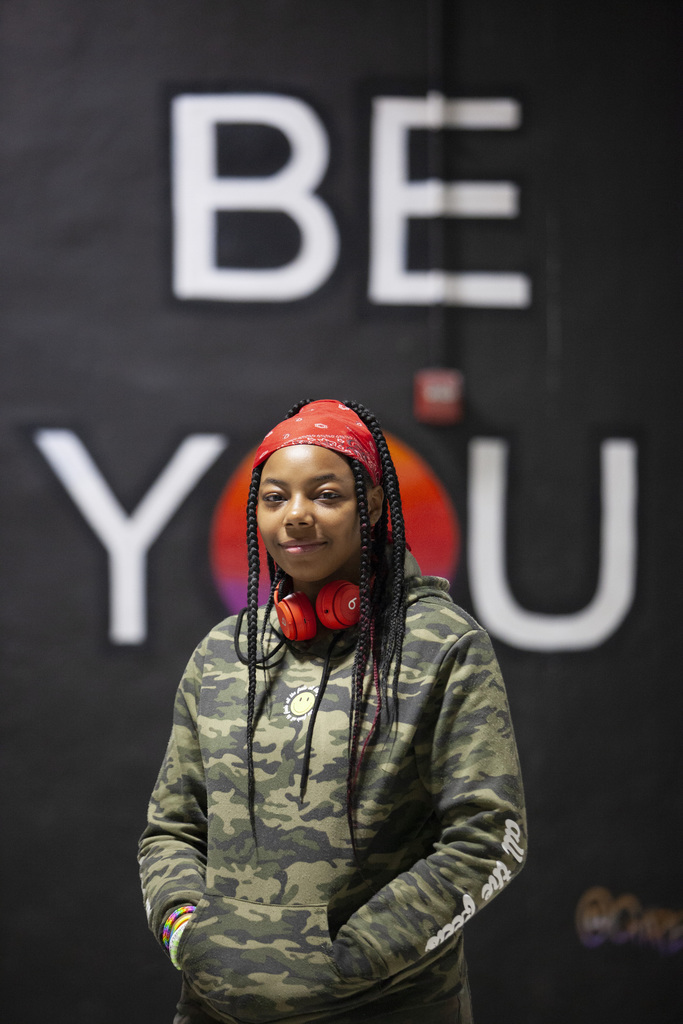 Student in front of mural reading "Be You"