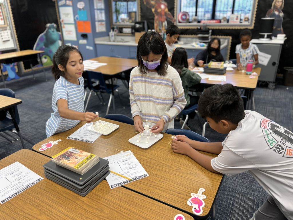 Students building towers with marshmallows and toothpicks.