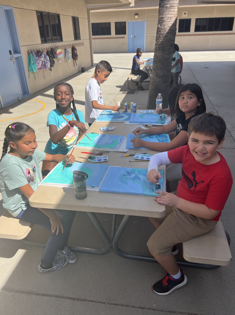 Students painting ocean waves.