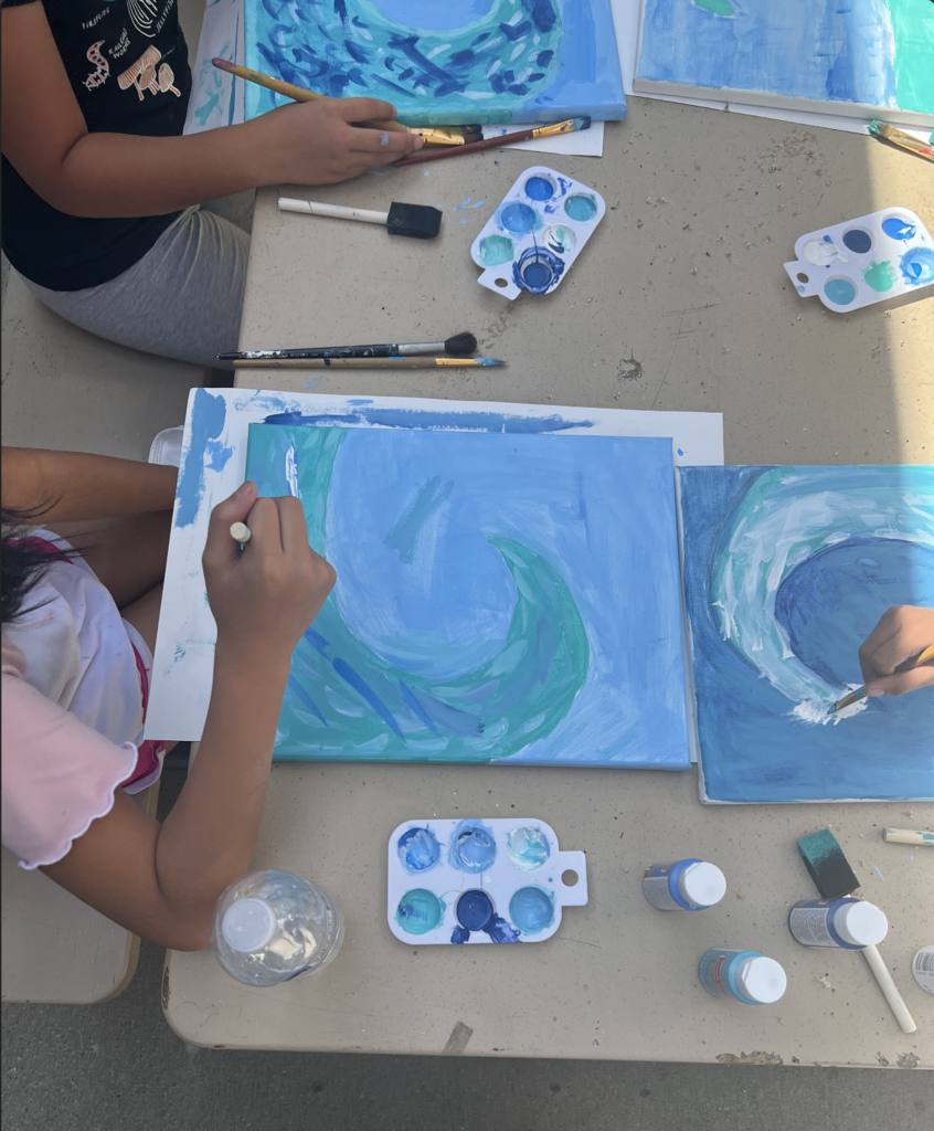 Students painting ocean waves.