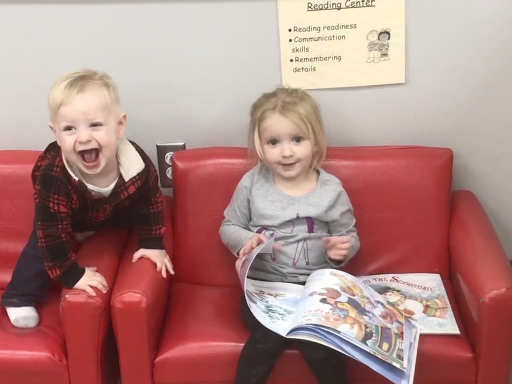 two kids reading on a couch