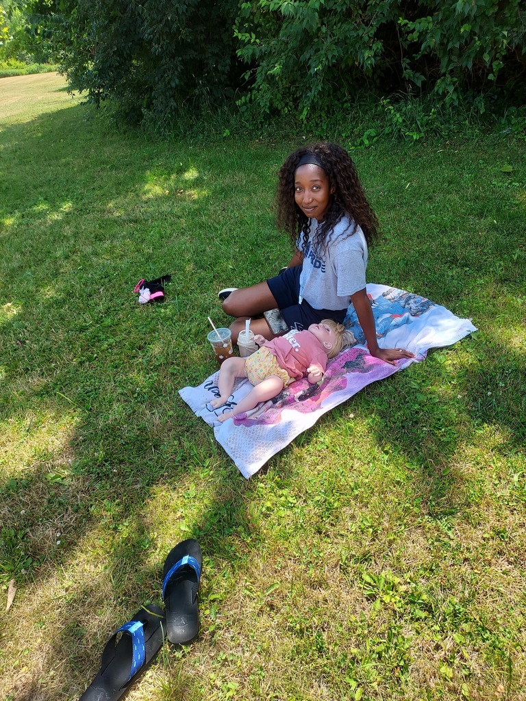 staff sitting on a blanket outside
