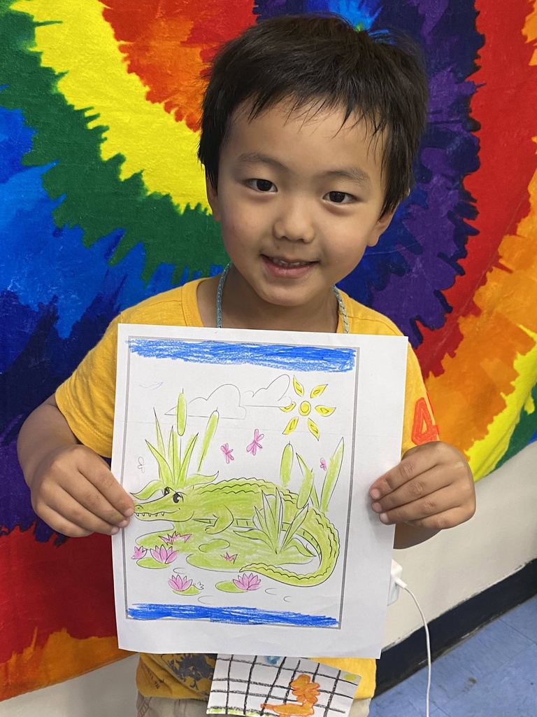 ELL camper holds his animal artwork during ELL camp