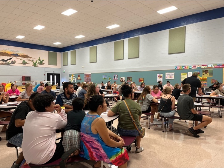 parents gathered I a room sitting at tables