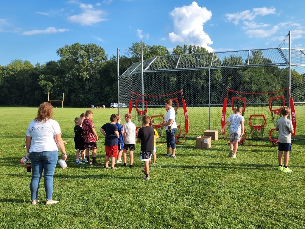 Kids tossing footballs into targets