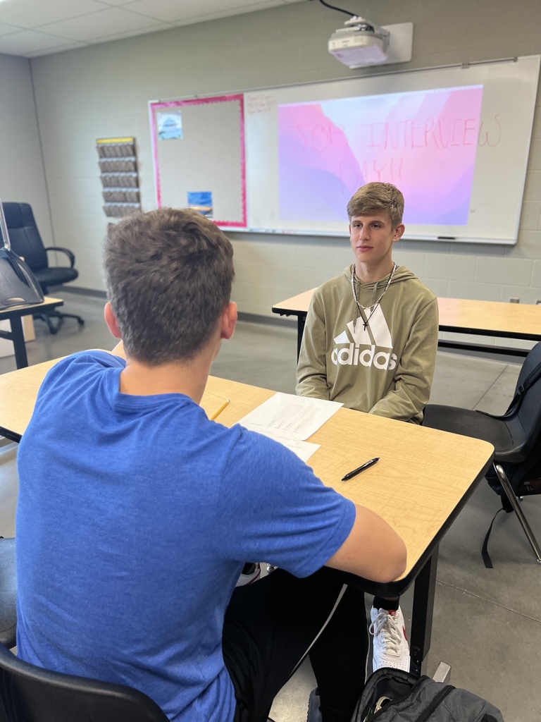 two students sitting at a table interviewing each other