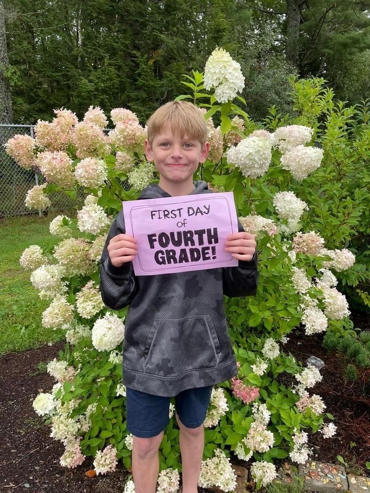 fourth grader with first day of school sign