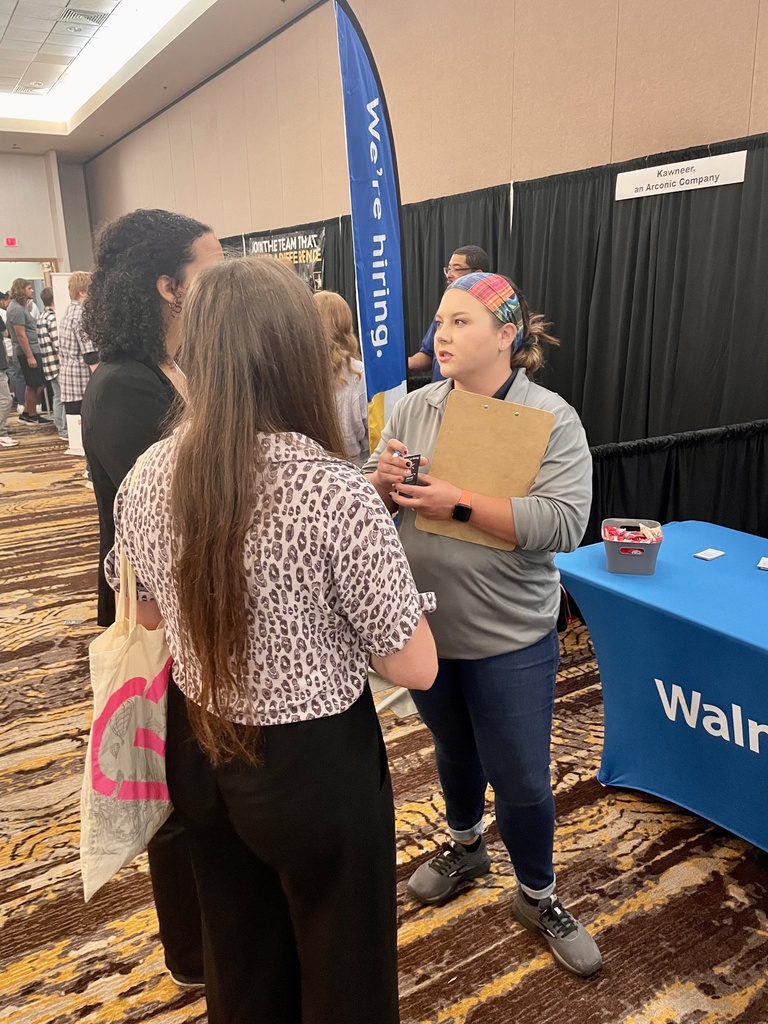 two students speaking with a company representative
