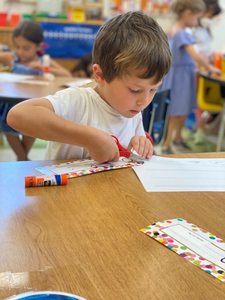 Kindergarten student cutting and pasting during a FUNdations lesson.