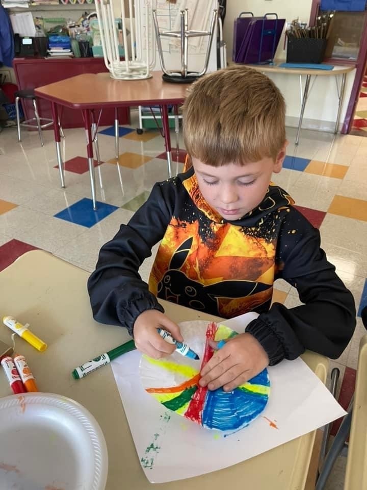 Student creating coffee filter dot