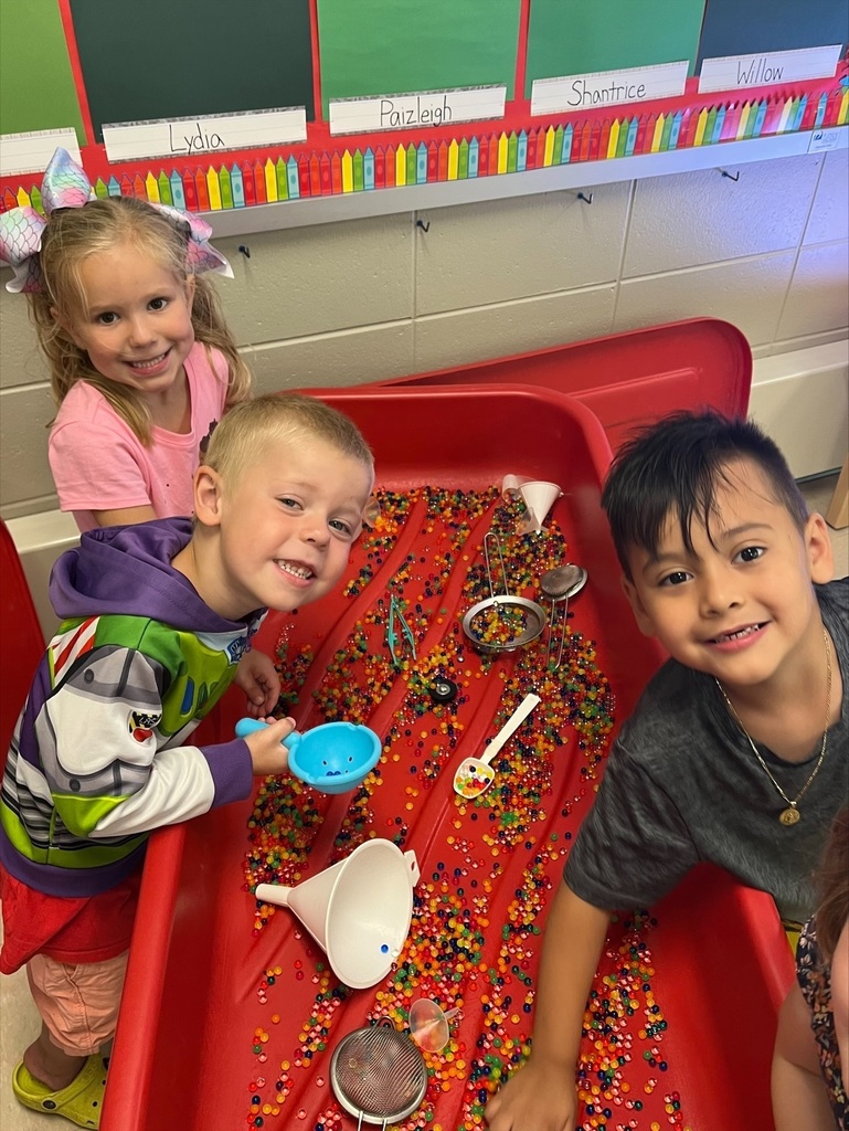 Three students playing at a sensory table