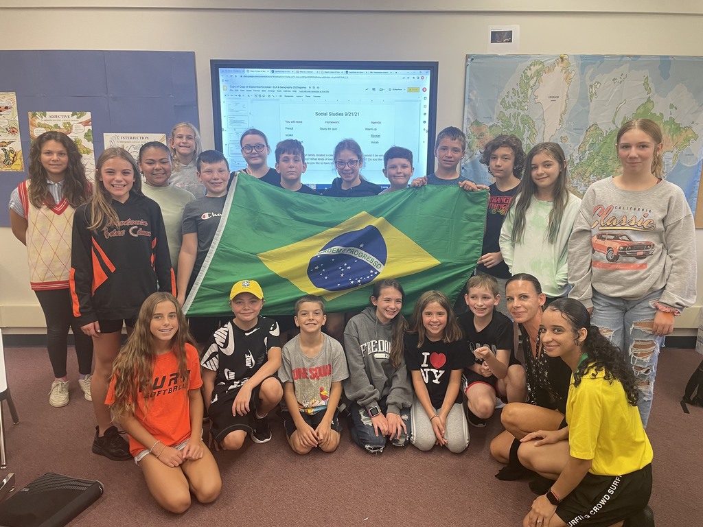 group of students hold a brazilian flag in a posed group photo