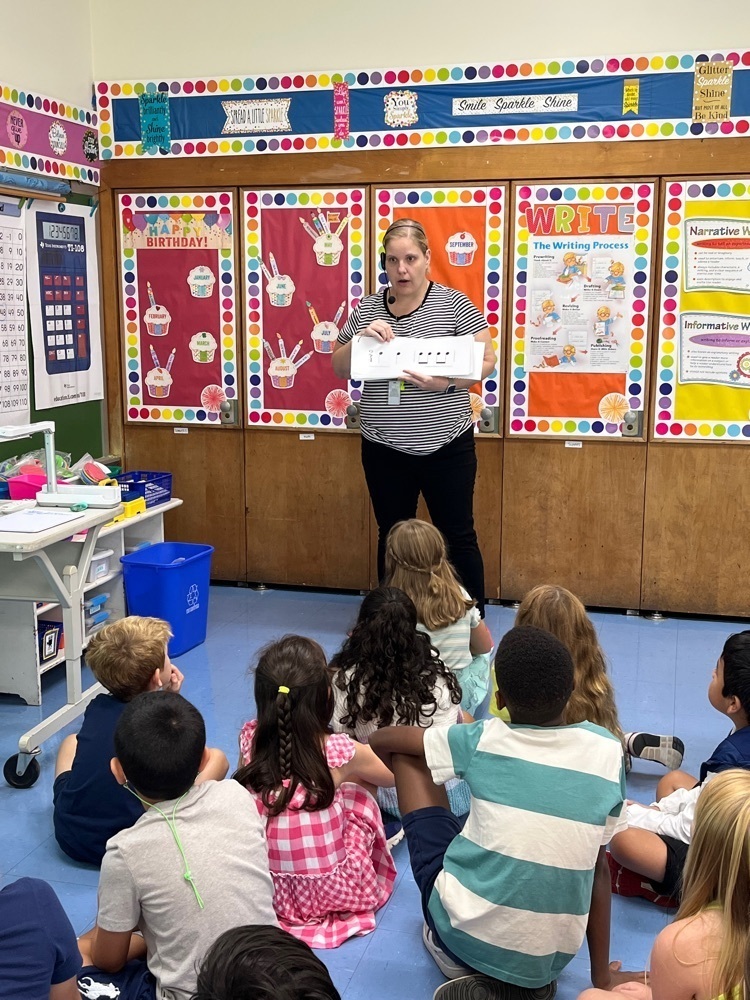 Students learning to read music notes with teacher.