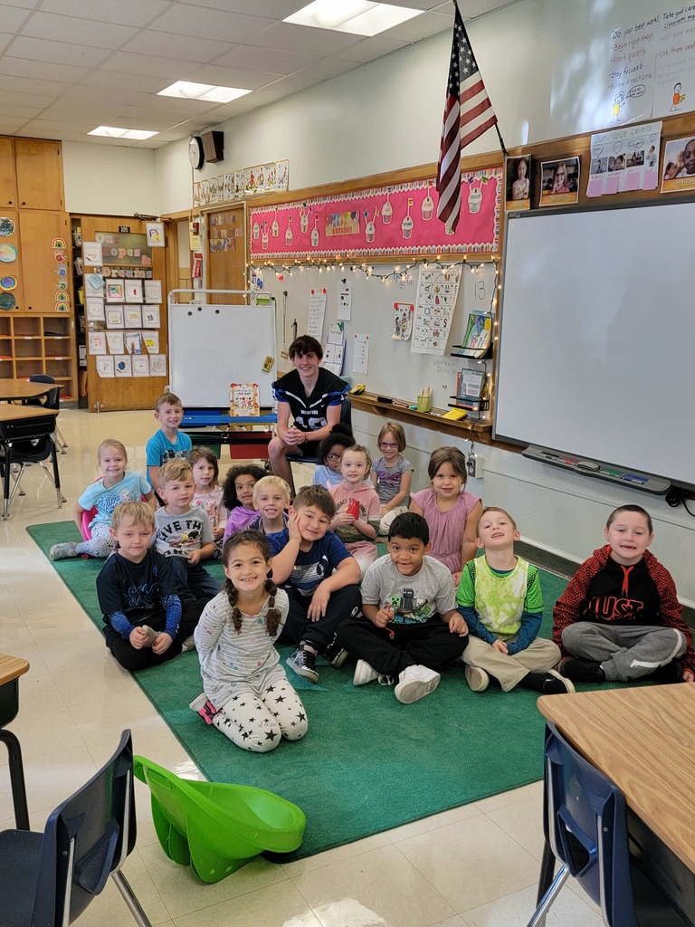 Football player reading to a class