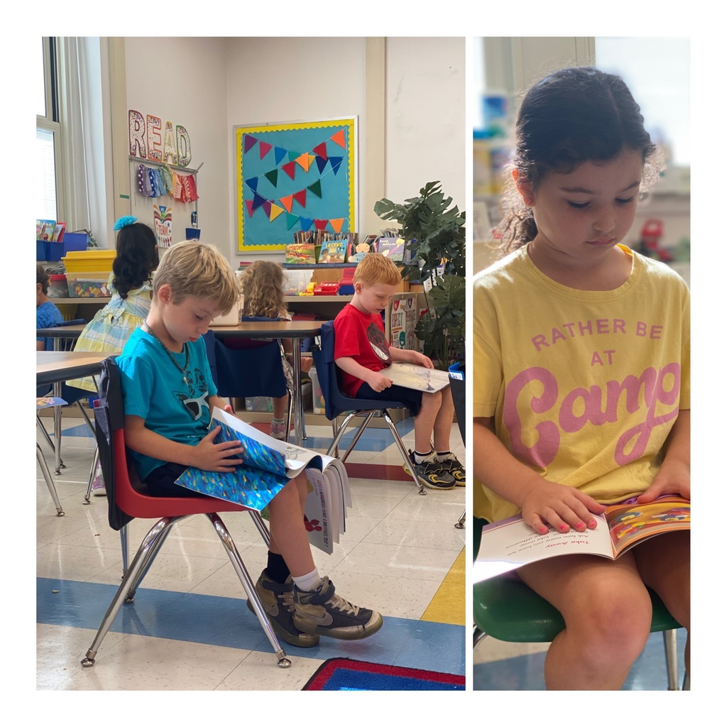 Kindergarten students engaged and reading at their tables.