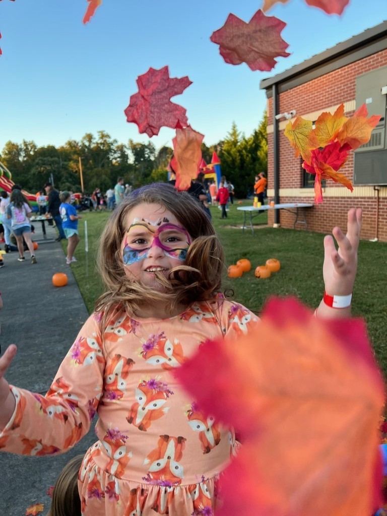 A girl playing in leaves