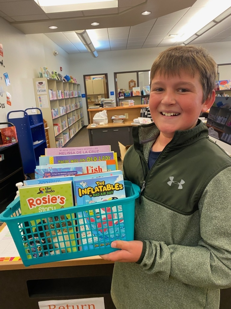 Boy holding a basket of books.