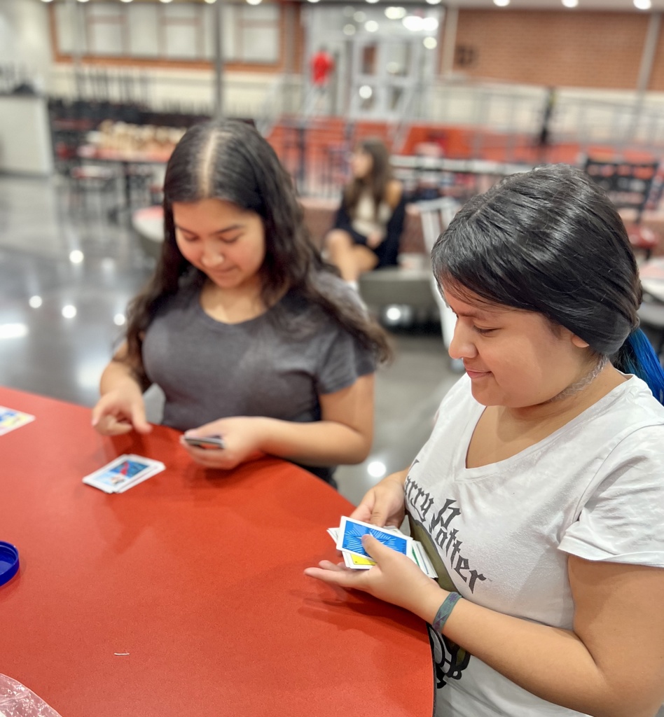 two students playing cards on a table