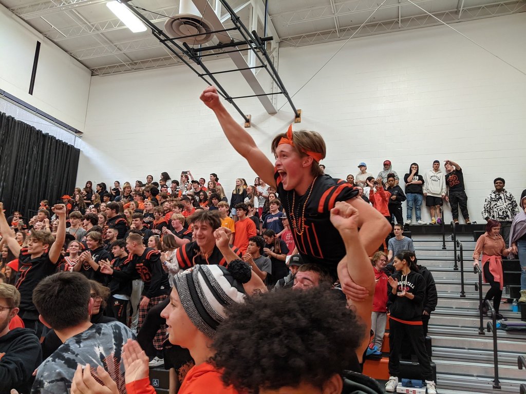 student on another student's shoulder cheers