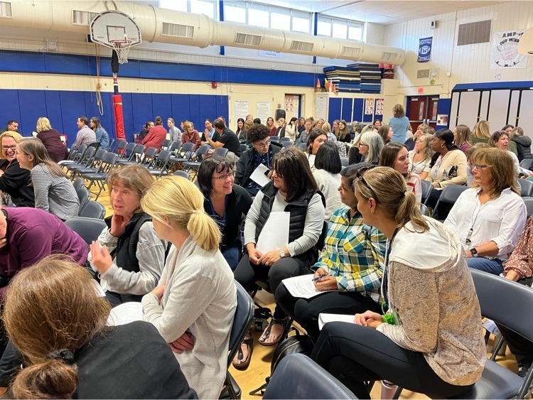 Staff members talking in small groups. 