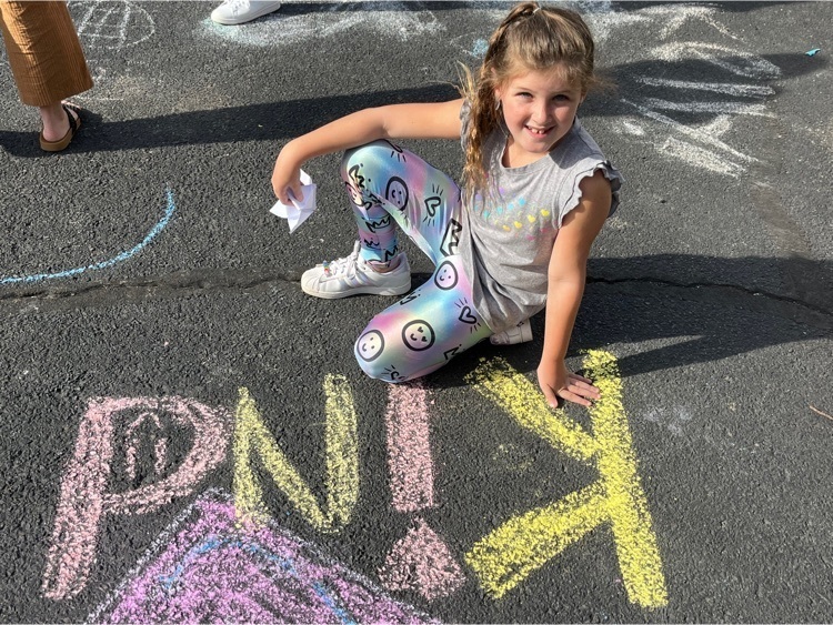 1st grade student uses chalk to write , Be Kind