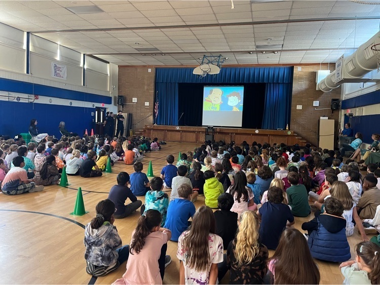 Grade 1-3 students watch a fire safety video in the gym. 