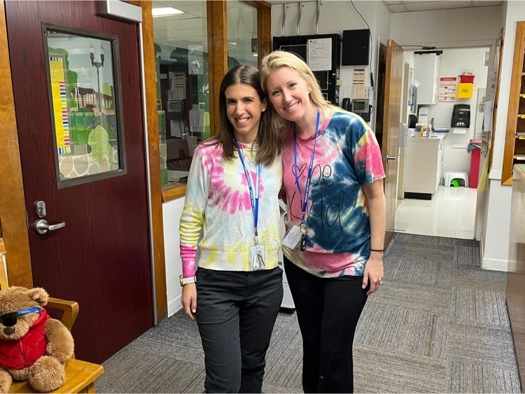 Two teachers show off their matching tie dye shirts.