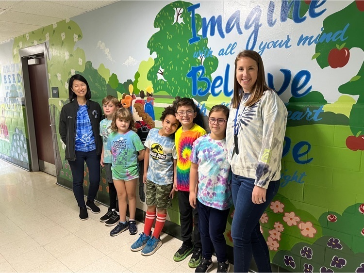 The principal and teacher shows off their tie dye shirts with  5 3rd grade students. 