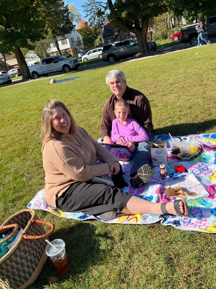 Fancher family enjoying a story and lunch on the lawn. 