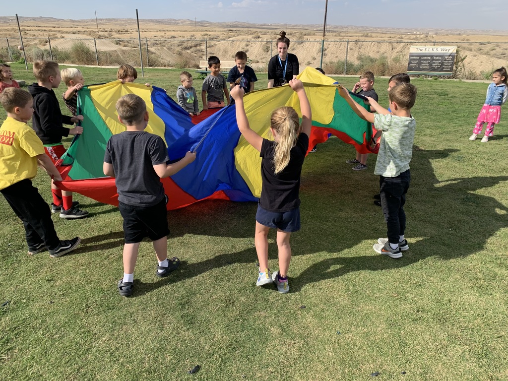 kids at recess with multicolored parachute