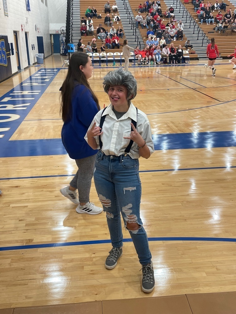 Student in suspenders with gray hair.