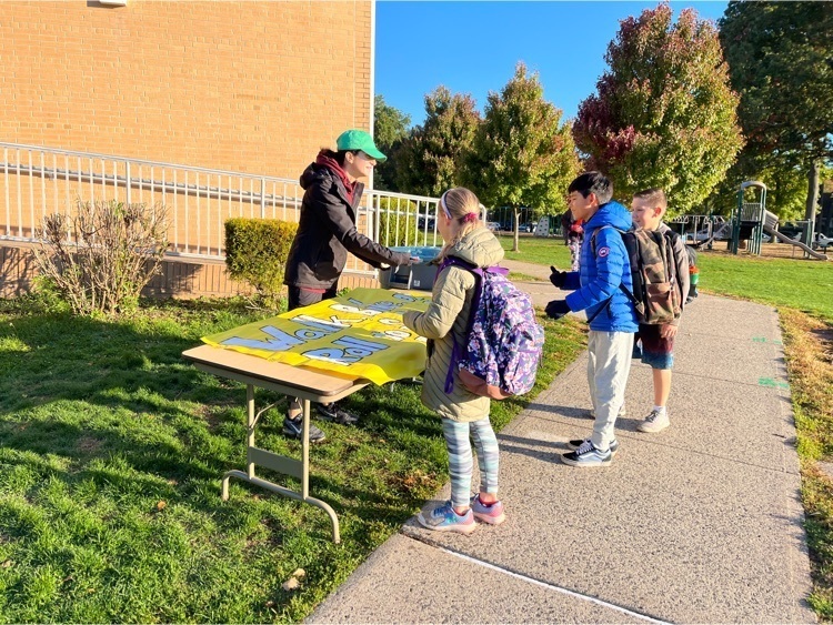 3 students sign the walk to school banner. 
