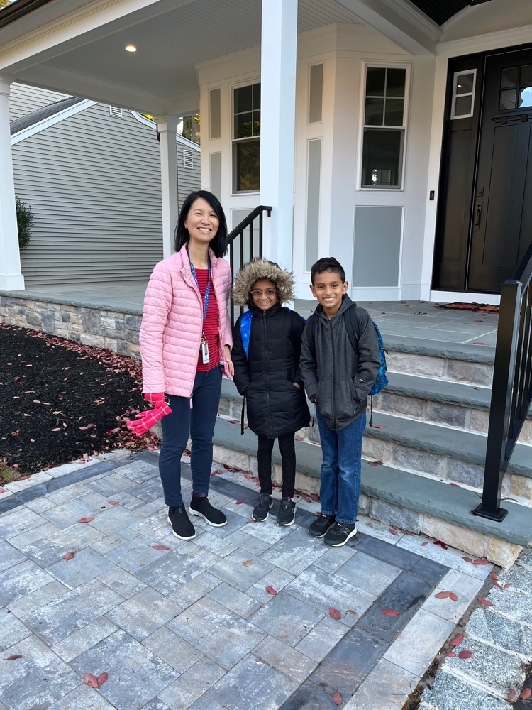 Principal arrives at the house of the student winners and get ready to walk to school. 