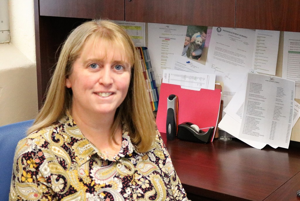 Patricia Ramos poses for picture at her desk