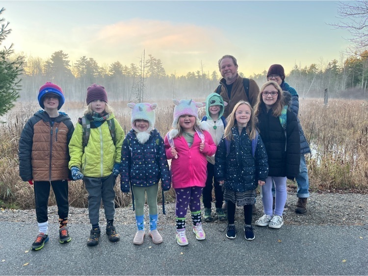 group of students and staff standing in front of a foggy swamp