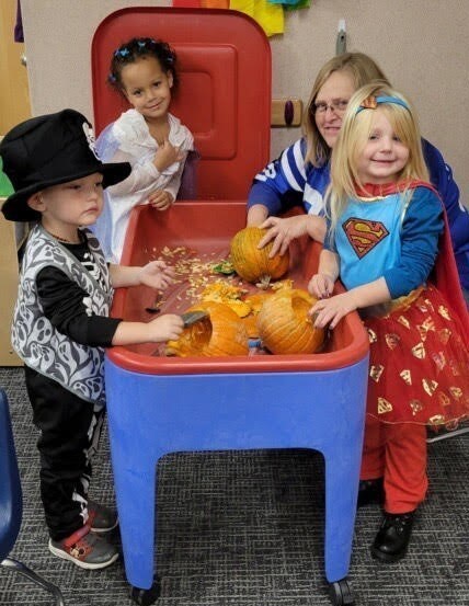 Students clean pumpkins with Mrs. Bacon