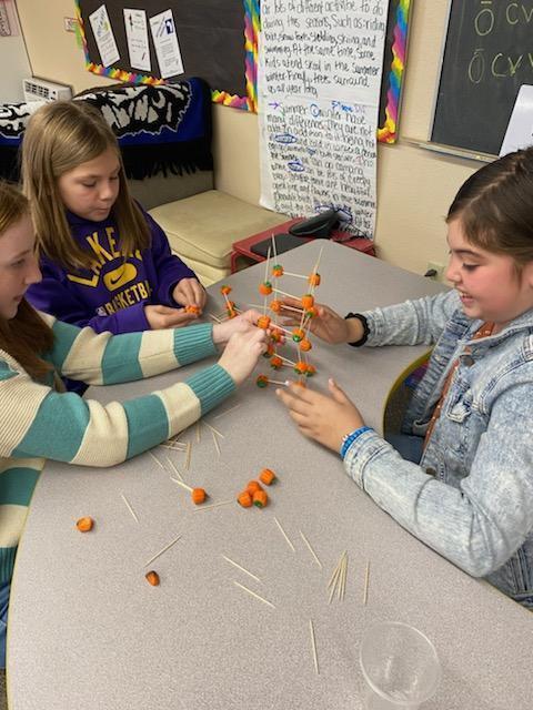 Girls are building with pumpkins.
