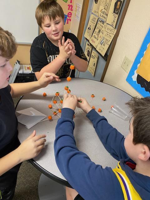 Boys are building with pumpkins.