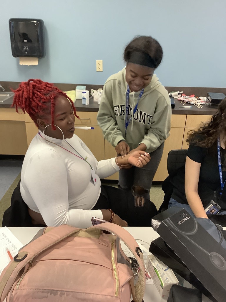 Student taking pulse and temperature on fellow student