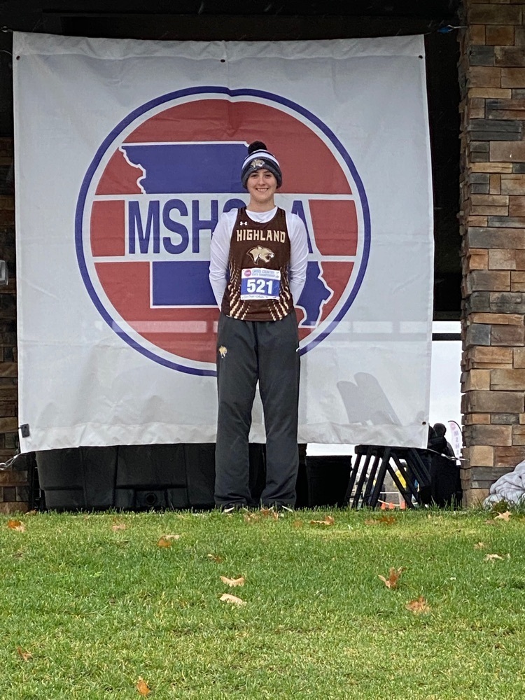 Kaycie Stahl in front of the MSHSAA sign at the state cross country meet.