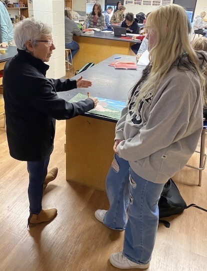 Deb Myers speaking with a student about her artwork. 