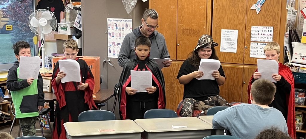 group of students read theater scripts in front of class