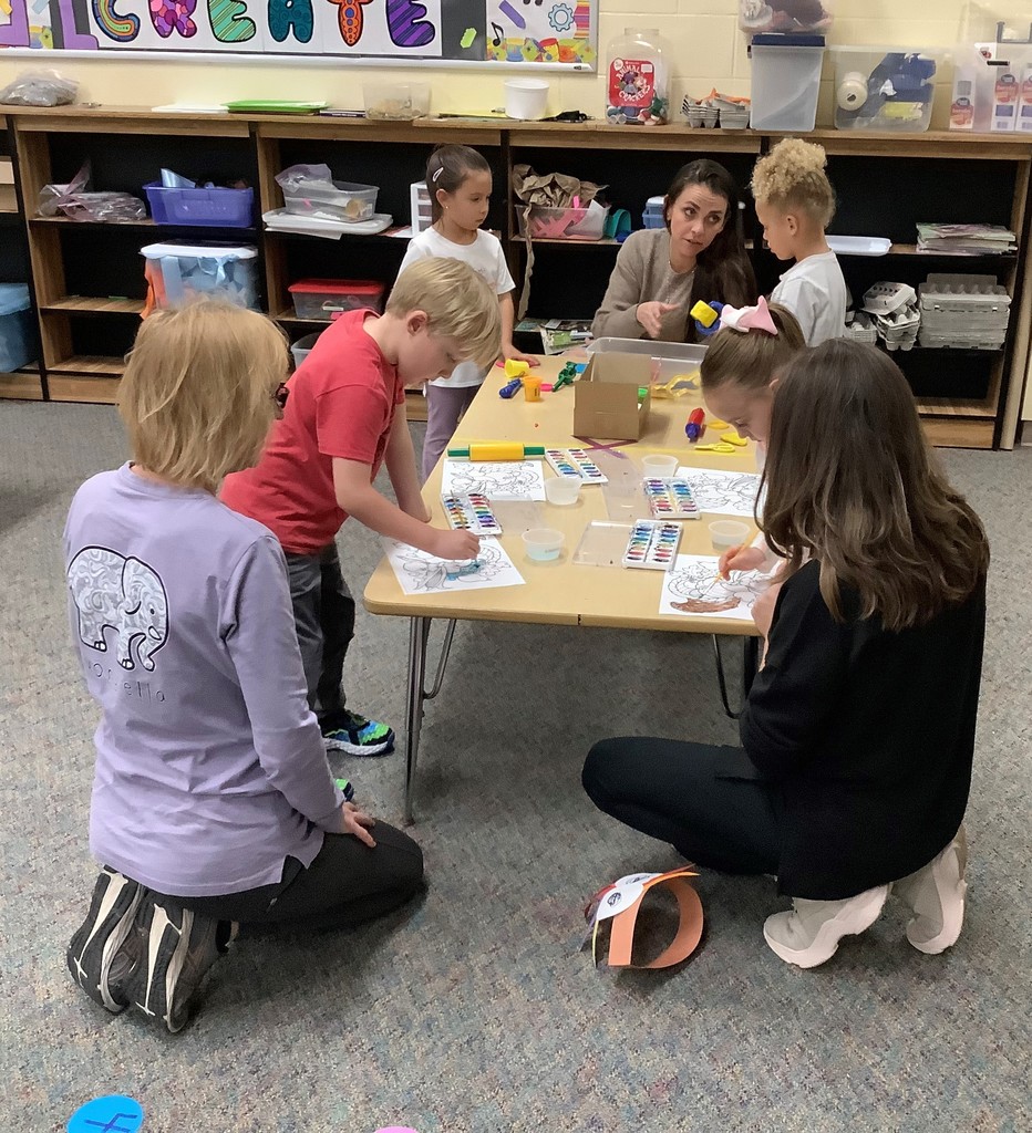 Parents and children painting at a small table