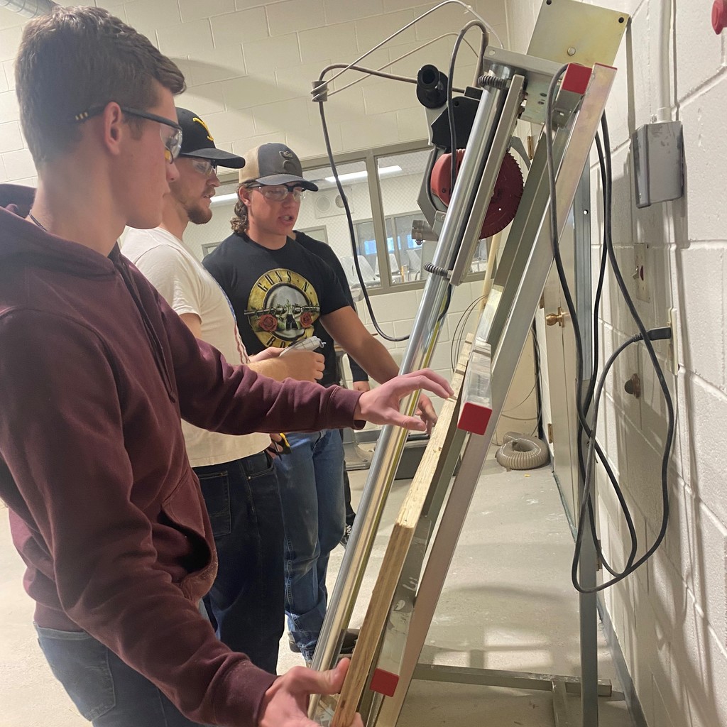 Woodshop students work on a cabinet project together