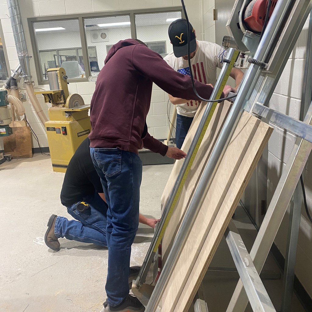 Woodshop students work on a cabinet project together