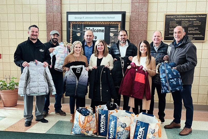 members of the local ahepa organization sanding with the coats from their drive