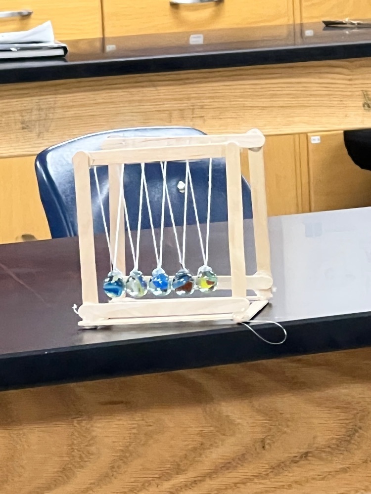 8th grade science is applying their knowledge of Newton’s 3rd Law by making their own Newton’s Cradle.